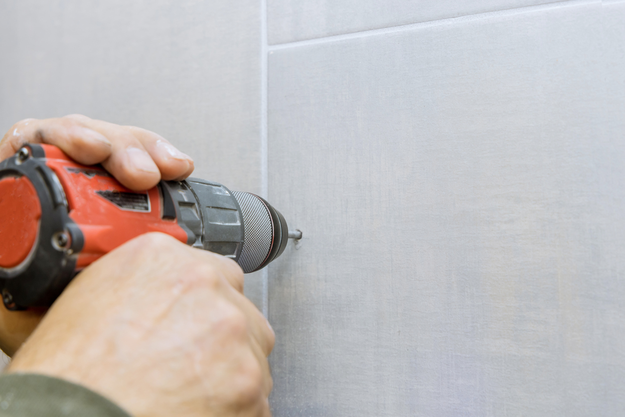 Close up view drilling hole in ceramic tiles on the wall of bathroom