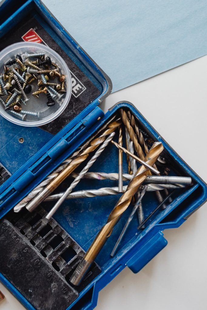 A selection of differently sized drill bits in a blue plastic case
