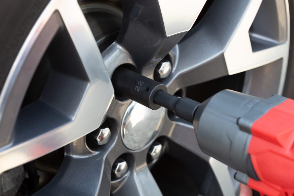 An impact wrench being used to change a tire.